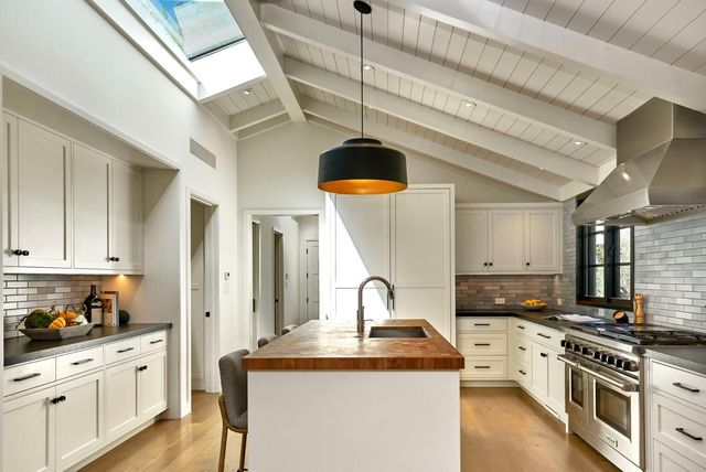 a kitchen with stainless steel appliances granite countertop a sink a stove and cabinets