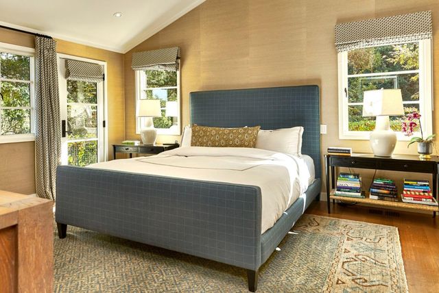 a bed sitting in a bedroom next to a window