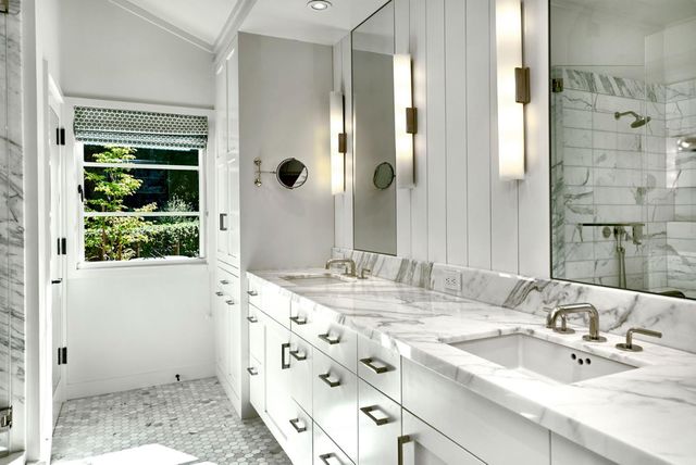 a bathroom with a granite countertop sink and a mirror