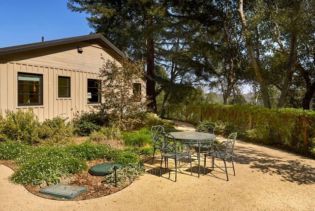 a view of a chair and table in backyard