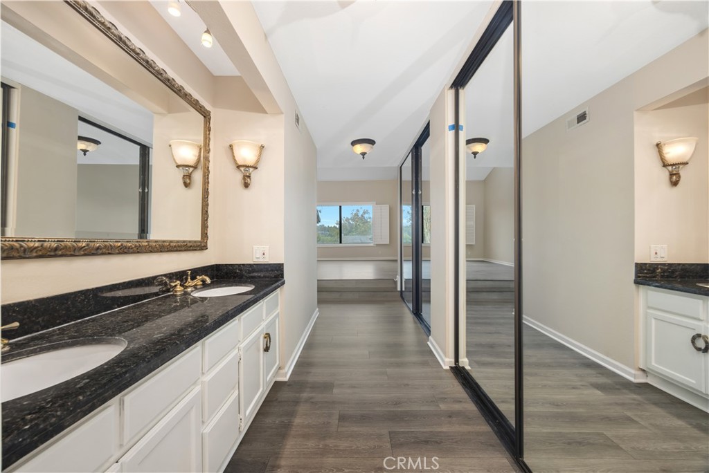 3 Palos, Unit 51 Irvine, CA 92612 - Photo 16 of 40 New flooring for primary bathroom. Granite countertop with dual vanities and elegant mirror.