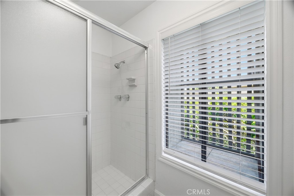 3 Palos, Unit 51 Irvine, CA 92612 - Photo 17 of 40 The walk-in shower in the primary bathroom with glass door closure and brand-new window blinds.