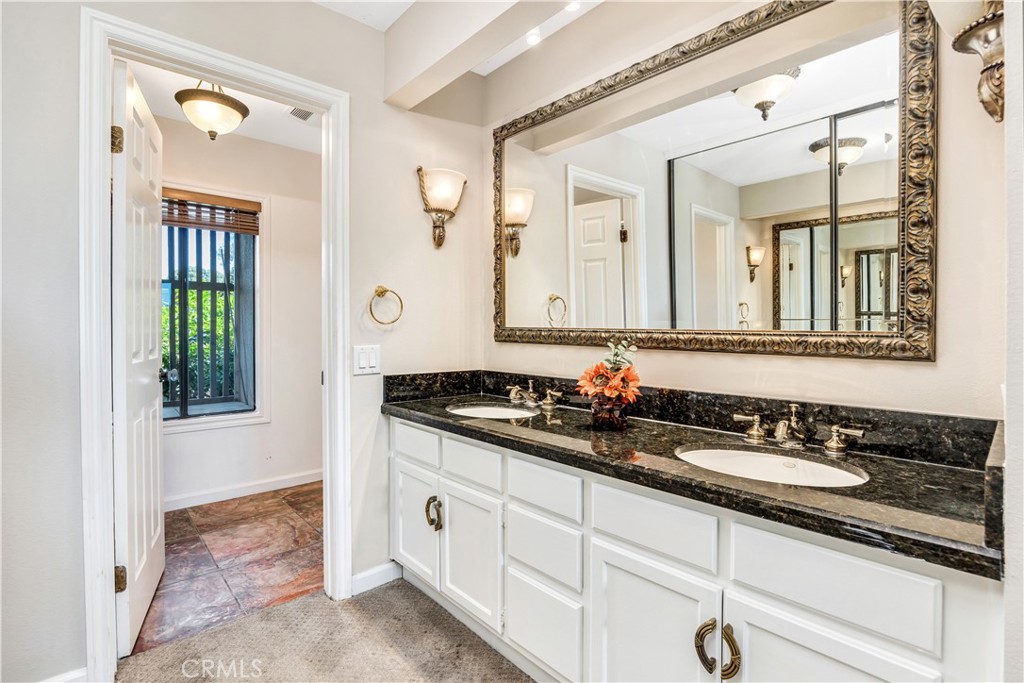 3 Palos, Unit 51 Irvine, CA 92612 - Photo 33 of 54 Granite countertop with dual vanities and elegant mirror.
