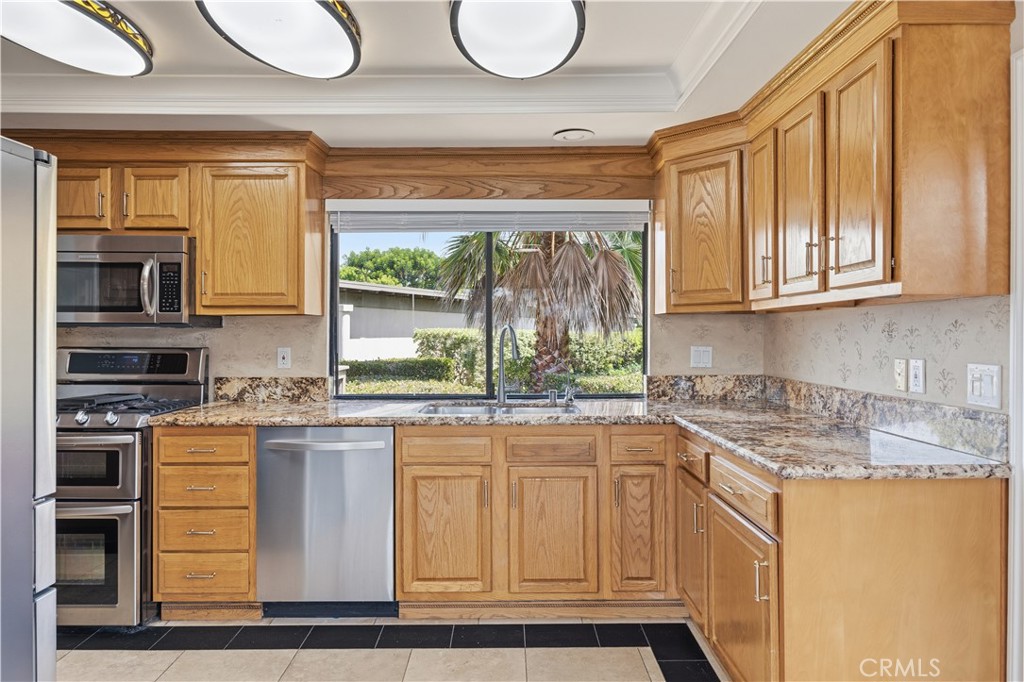 3 Palos, Unit 51 Irvine, CA 92612 - Photo 4 of 40 The newly refreshed wooden kitchen cabinets with brand-new handles and window blinds. The window above the kitchen sink showcases beautiful landscaping outside all year long. Granite countertops, and stainless steel appliances with double oven, microwave with unique light fixtures.