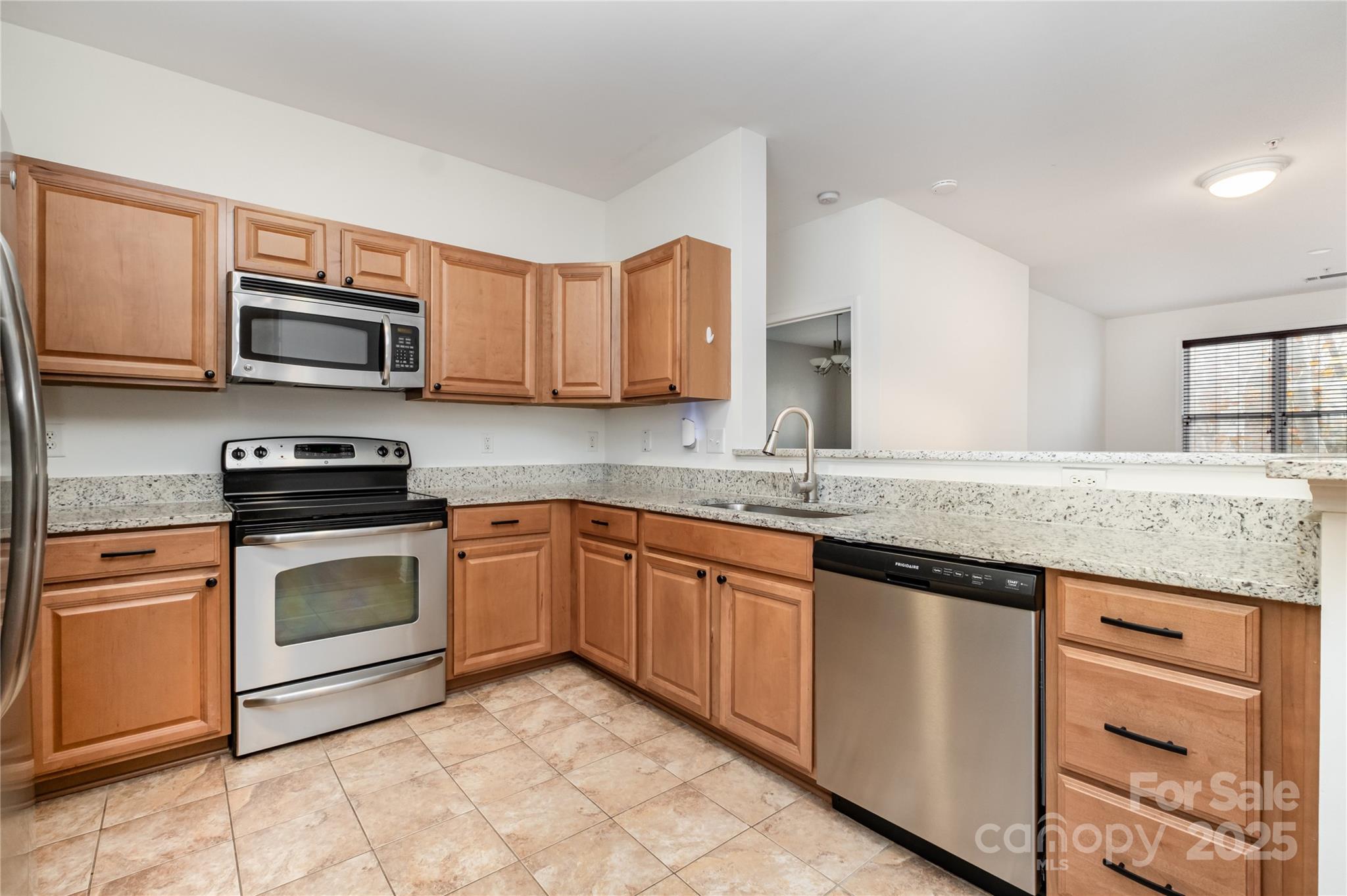 1000 East Woodlawn Road, Unit 217 Charlotte, NC 28209 - Photo 7 of 19 a kitchen with granite countertop cabinets stainless steel appliances and a sink