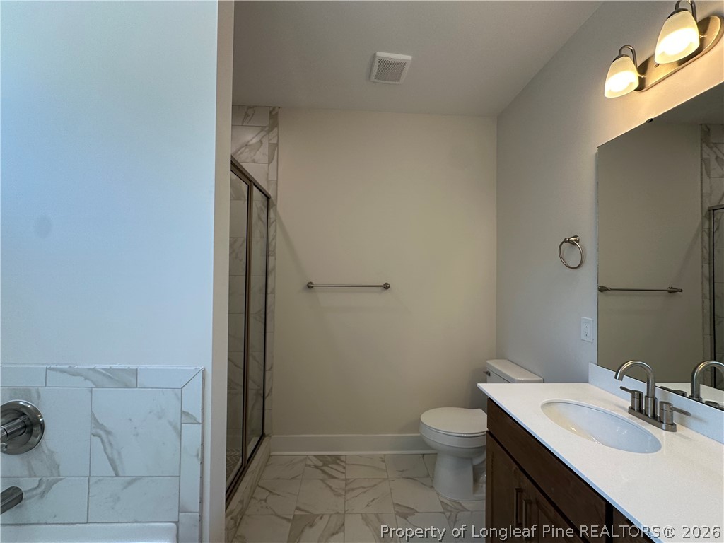 2908 Calloway Road Raeford, NC 28376 - Photo 14 of 25 a bathroom with a granite countertop sink toilet and shower