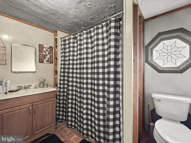a bathroom with a toilet sink vanity and mirror