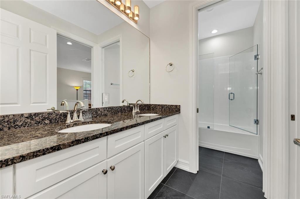 9154 Chula Vista Street, Unit 1331 Naples, FL 34113 - Photo 13 of 25 a bathroom with a granite countertop sink and a mirror