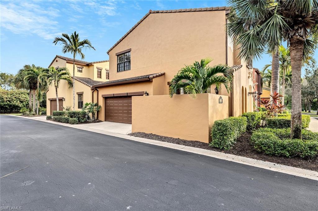 9154 Chula Vista Street, Unit 1331 Naples, FL 34113 - Photo 15 of 25 a front view of a house with a yard and garage