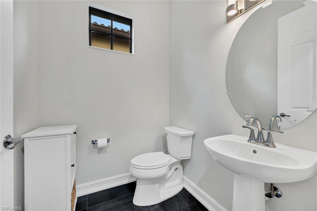 9154 Chula Vista Street, Unit 1331 Naples, FL 34113 - Photo 16 of 25 a bathroom with a toilet sink and mirror
