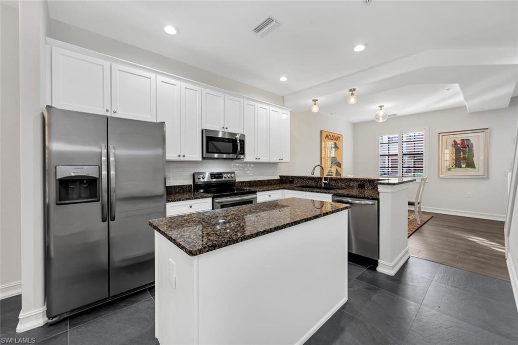 9154 Chula Vista Street, Unit 1331 Naples, FL 34113 - Photo 2 of 25 a kitchen with a refrigerator a sink a stove a microwave and cabinets