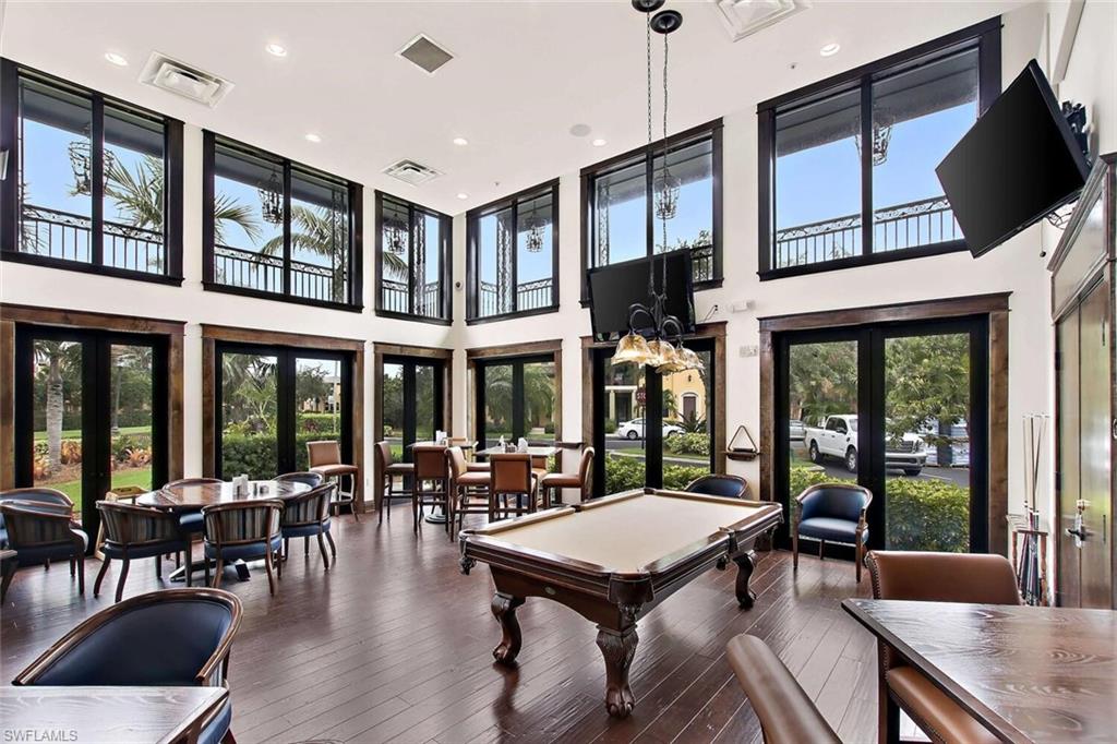 9154 Chula Vista Street, Unit 1331 Naples, FL 34113 - Photo 22 of 25 a living room with furniture a floor to ceiling window and outdoor view