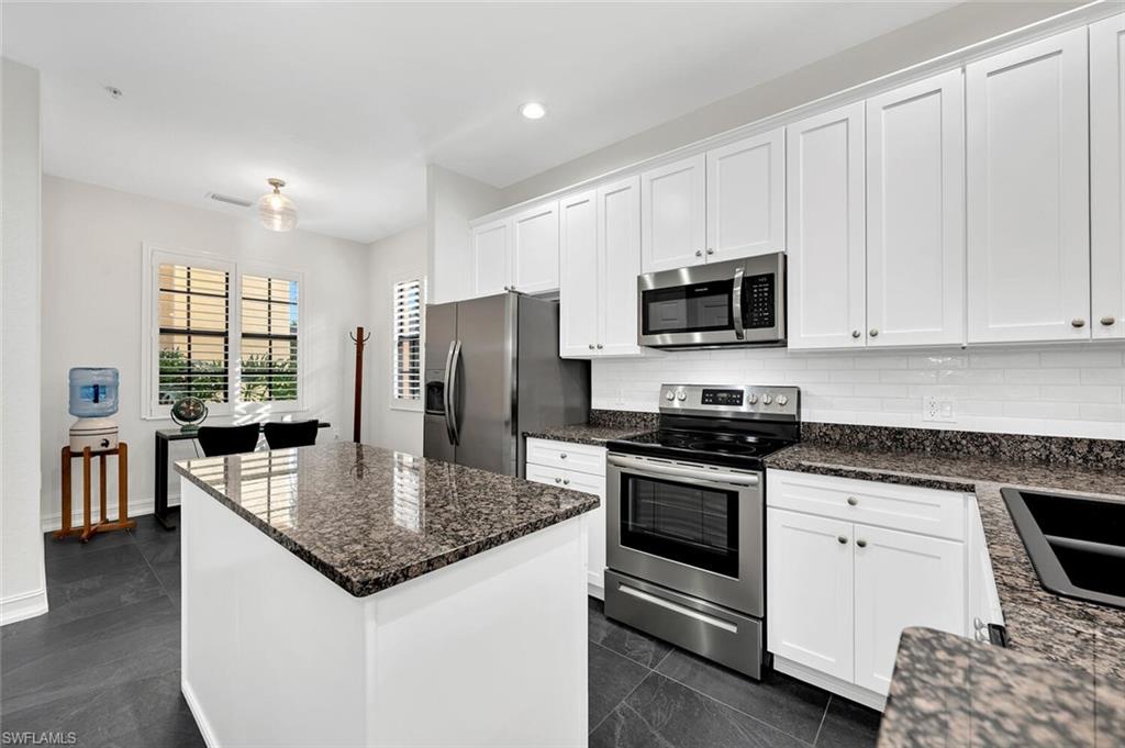 9154 Chula Vista Street, Unit 1331 Naples, FL 34113 - Photo 3 of 25 a kitchen with stainless steel appliances granite countertop a stove microwave and refrigerator