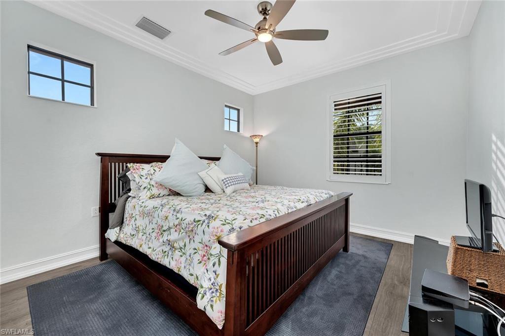 9154 Chula Vista Street, Unit 1331 Naples, FL 34113 - Photo 10 of 25 a bedroom with a bed and a flat screen tv