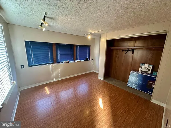a view of empty room with wooden floor and window