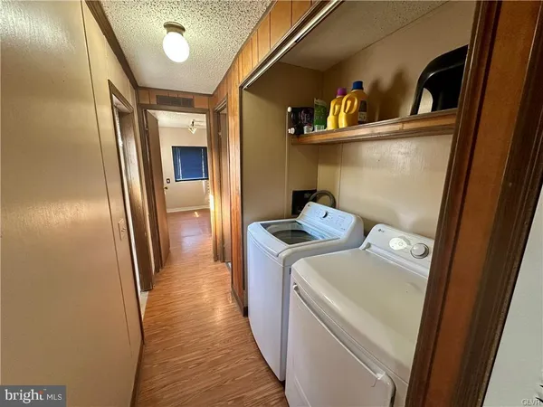 a utility room with wooden floor washer and dryer