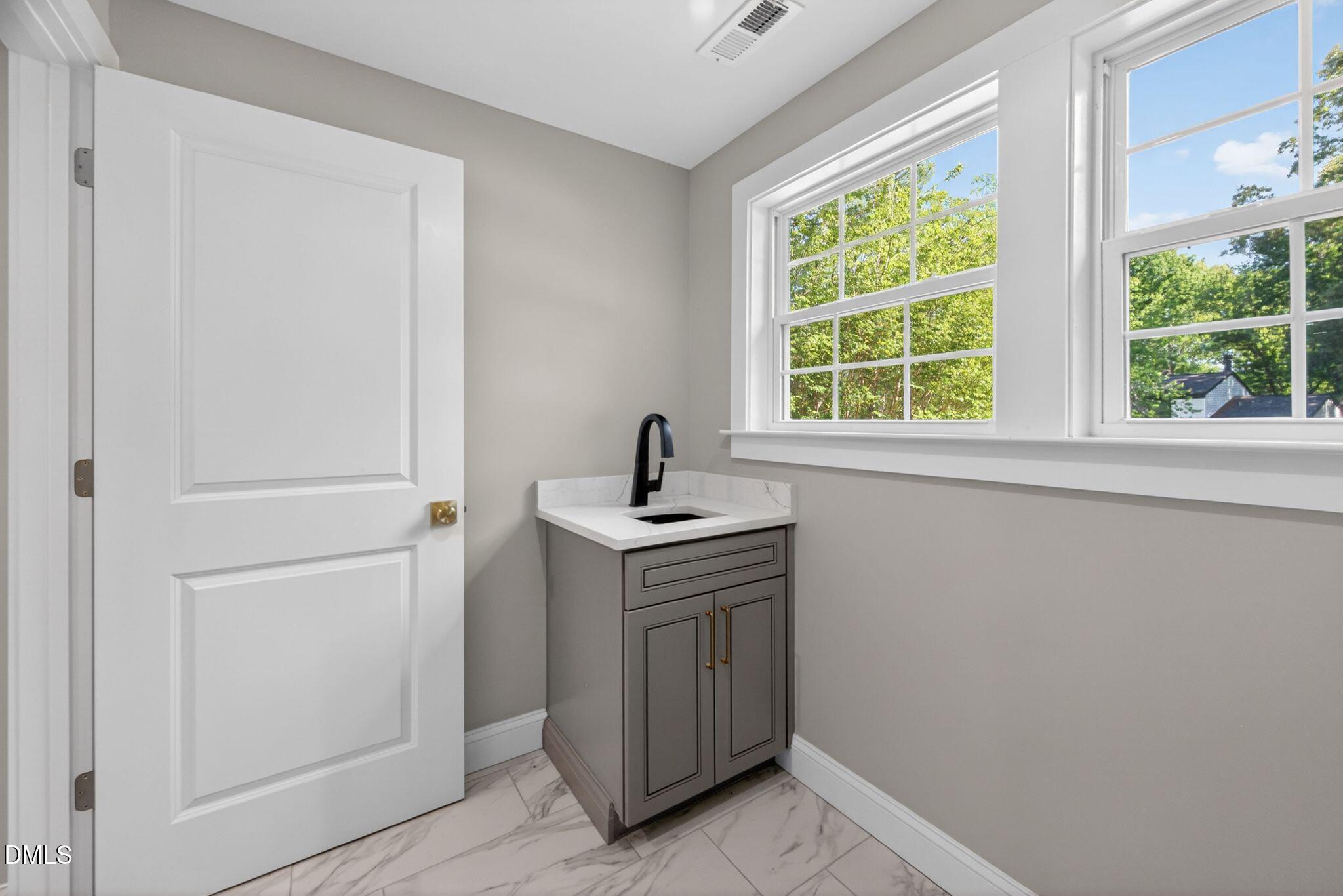 313 Crown Oaks Drive Raleigh, NC 27615 - Photo 32 of 60 a view of a sink and window in a room