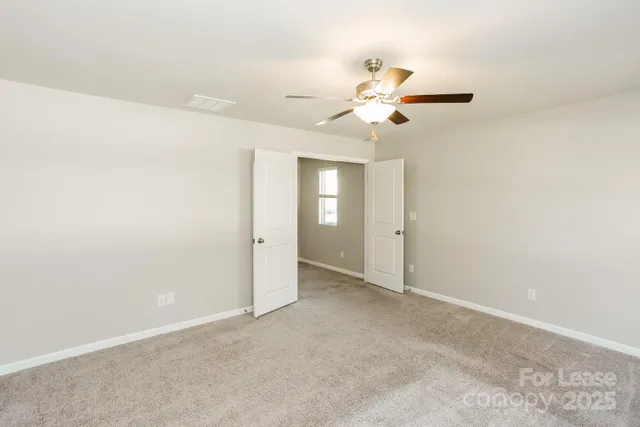 an empty room with closet and fan