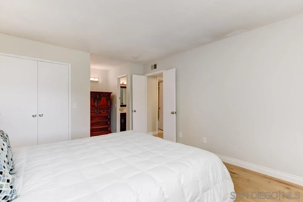 433 Village Run East Encinitas, CA 92024 - Photo 11 of 25 a bedroom with a large bed and a chandelier