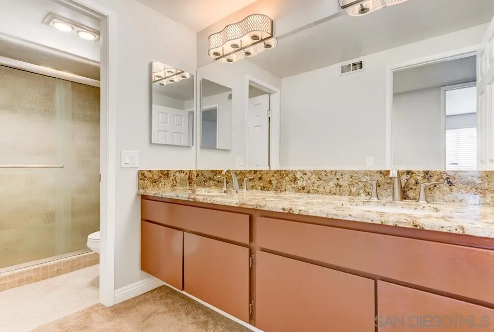 433 Village Run East Encinitas, CA 92024 - Photo 17 of 25 a bathroom with a granite countertop sink and a mirror