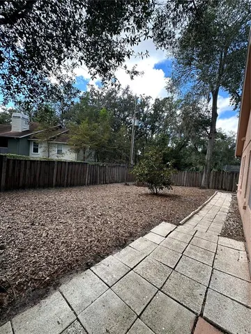 a view of backyard with wooden fence