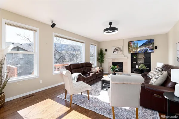 a living room with furniture a fireplace and a large window