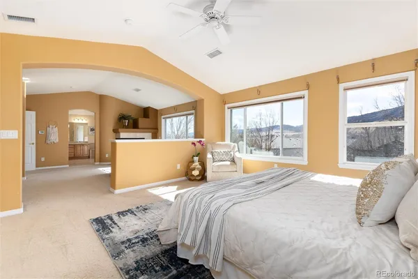 a bedroom with a bed and large windows