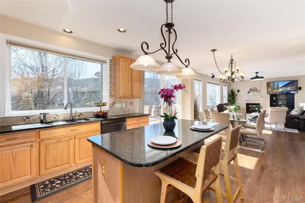 a view of a dining room and livingroom with furniture wooden floor a chandelier