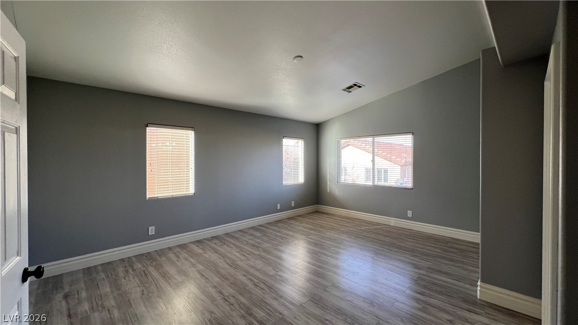 258 Rustic Club Way Las Vegas, NV 89148 - Photo 11 of 25 This spacious room features vaulted ceilings and light wood flooring, perfect for versatile living.