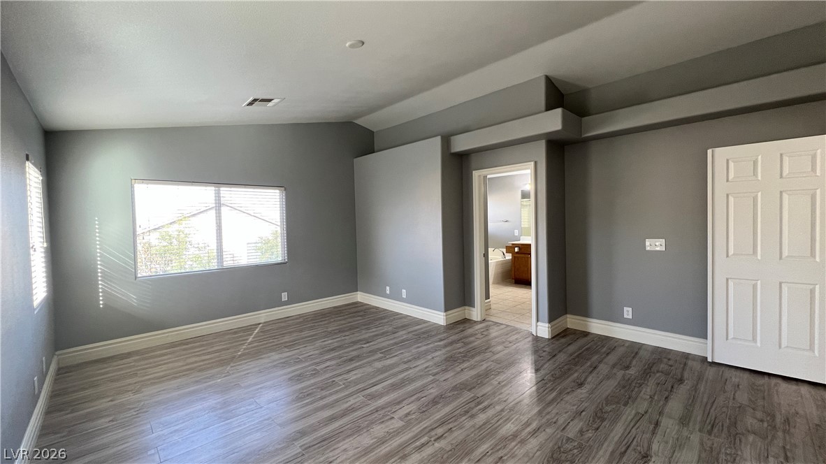 258 Rustic Club Way Las Vegas, NV 89148 - Photo 12 of 25 This spacious bedroom offers ample natural light and direct access to a private bathroom.