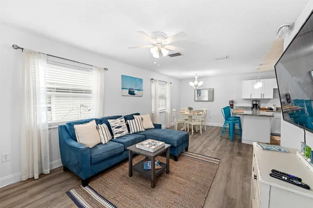 a living room with furniture and kitchen view