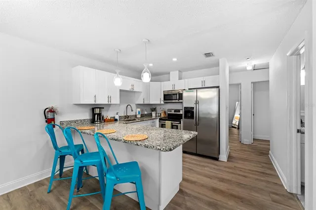 a kitchen with a refrigerator and a stove top oven