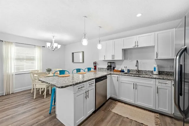 a kitchen with granite countertop a sink a counter space appliances and cabinets