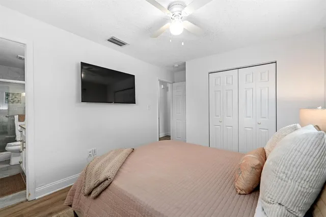 a bedroom with a bed a flat tv screen and a walk in closet