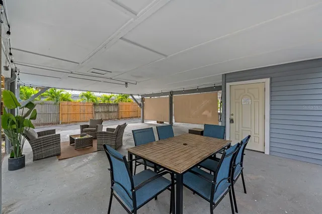 a view of a patio with a table and chairs under an umbrella