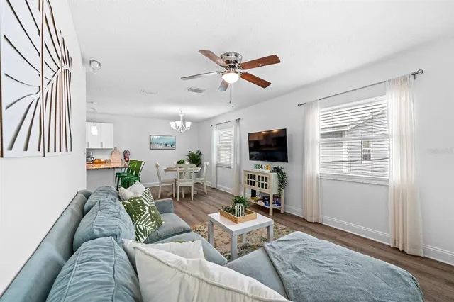 a living room with furniture a flat screen tv and a window