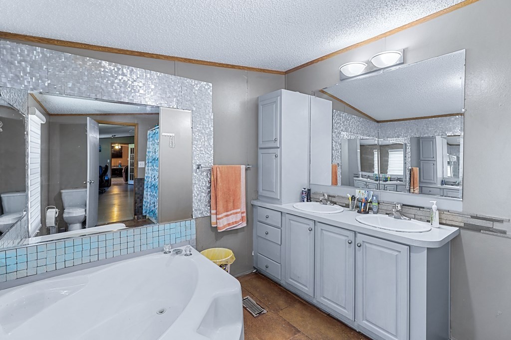 2676 South Riverbend Road Dalton, GA 30721 - Photo 24 of 28 a bathroom with a tub sink and mirror
