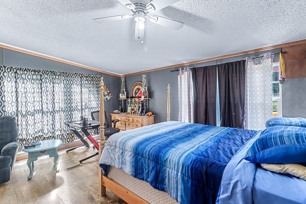 2676 South Riverbend Road Dalton, GA 30721 - Photo 10 of 28 a bedroom with a large bed and a chandelier