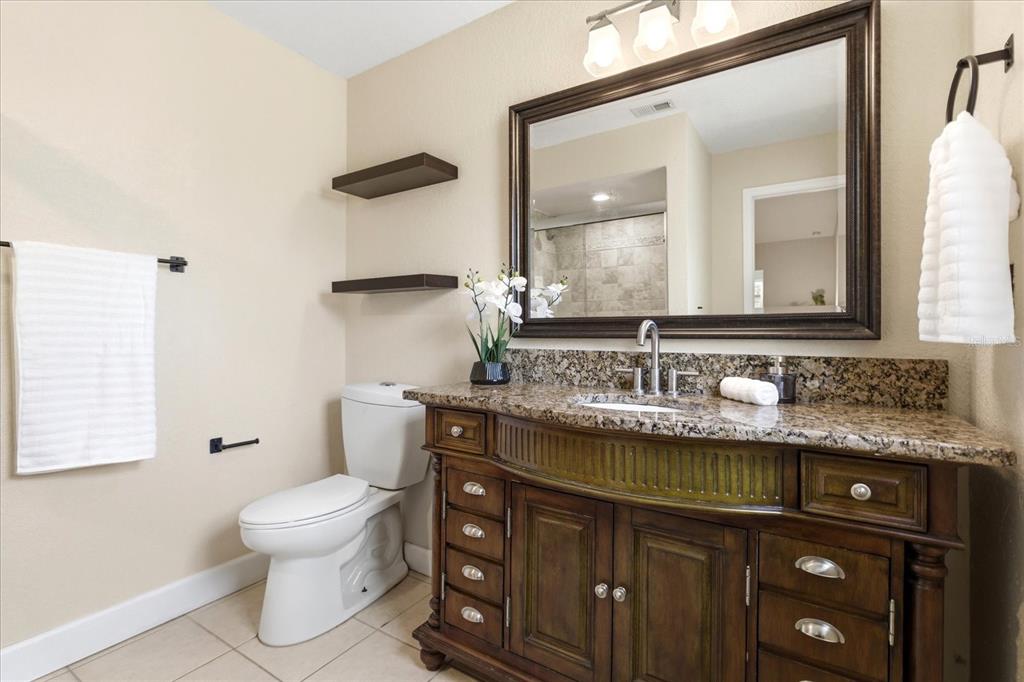393 Wekiva Cove Road Longwood, FL 32779 - Photo 22 of 49 a bathroom with a granite countertop sink a toilet and a mirror