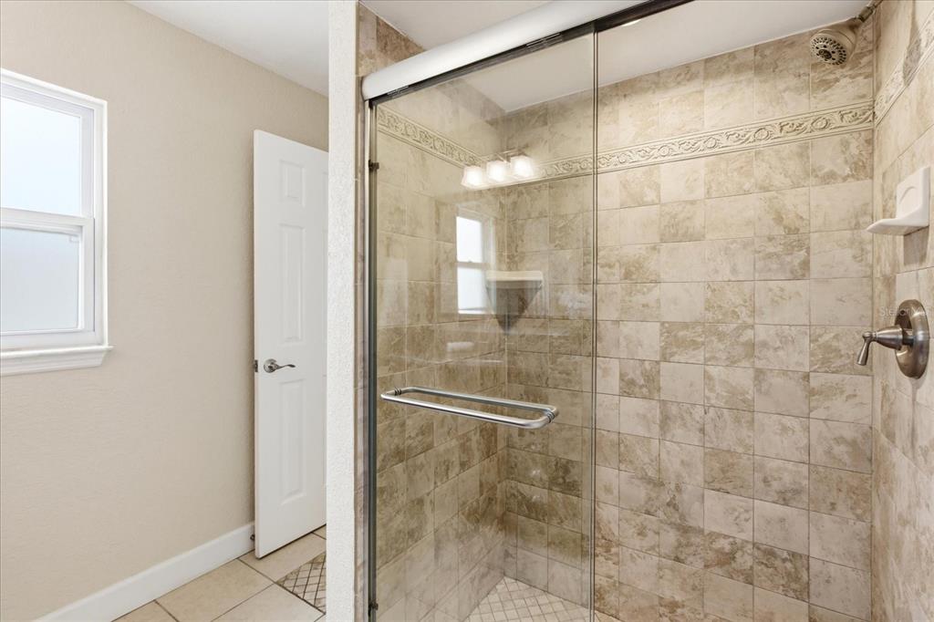 393 Wekiva Cove Road Longwood, FL 32779 - Photo 23 of 49 a bathroom with a glass shower door