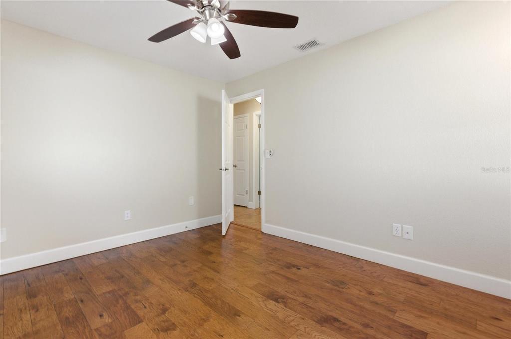 393 Wekiva Cove Road Longwood, FL 32779 - Photo 28 of 49 an empty room with wooden floor and a ceiling fan