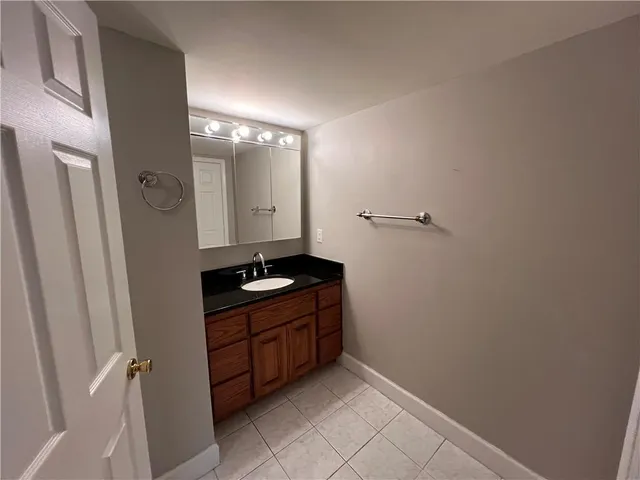 a bathroom with a granite countertop sink and a mirror