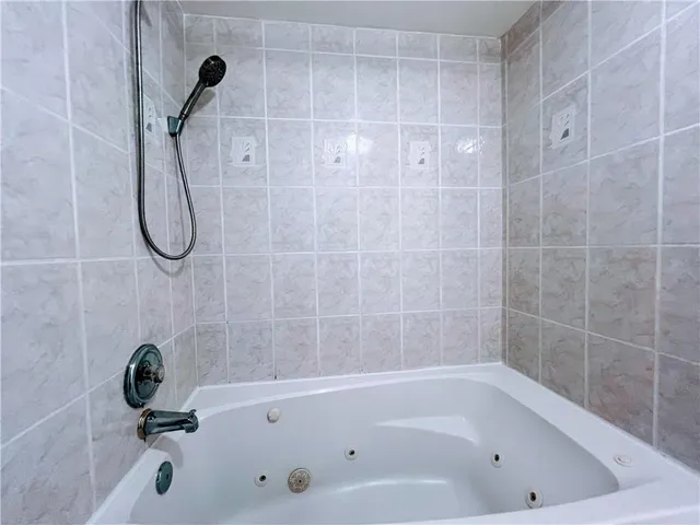 a bathroom with a bath tub with a shower