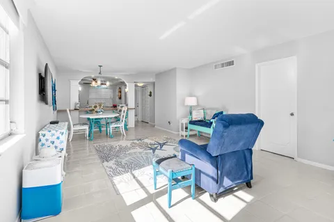 a living room with furniture and a dining table with kitchen view