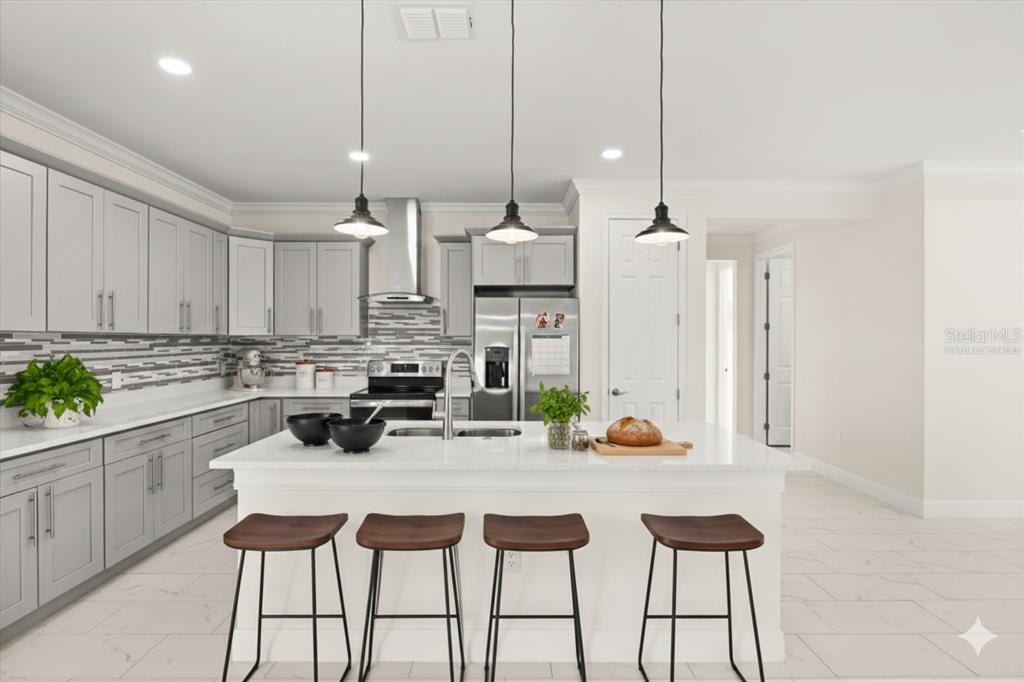 840 Oaks Shores Road Leesburg, FL 34748 - Photo 5 of 25 a kitchen with stainless steel appliances kitchen island granite countertop a table chairs and white cabinets