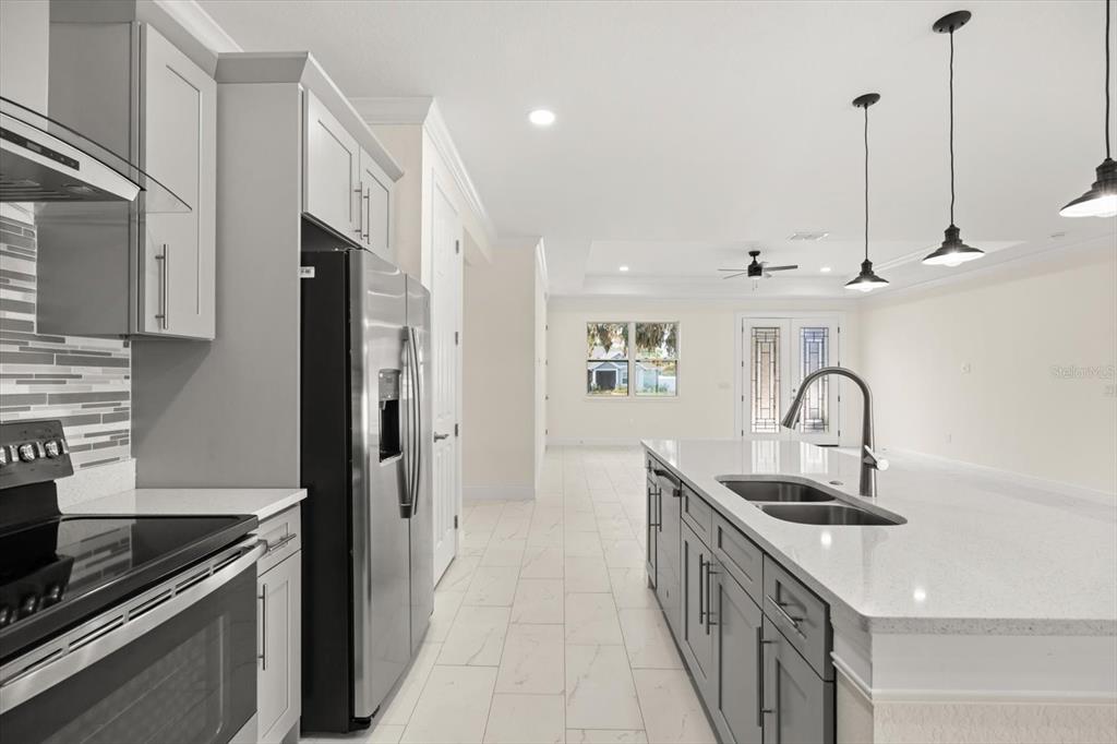 840 Oaks Shores Road Leesburg, FL 34748 - Photo 10 of 25 a kitchen with stainless steel appliances granite countertop a sink a stove and a refrigerator