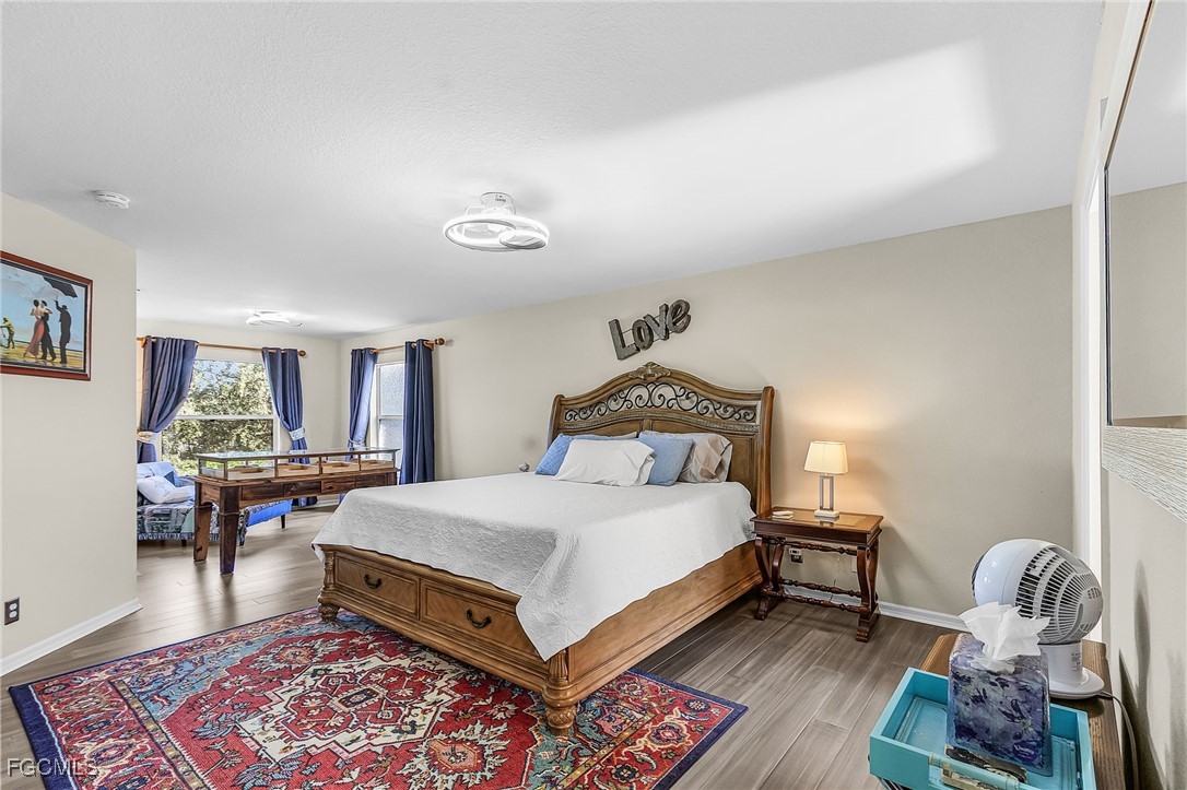 9021 Falcon Pointe Loop Fort Myers, FL 33912 - Photo 27 of 39 a bedroom with a bed and a table in it with wooden floor