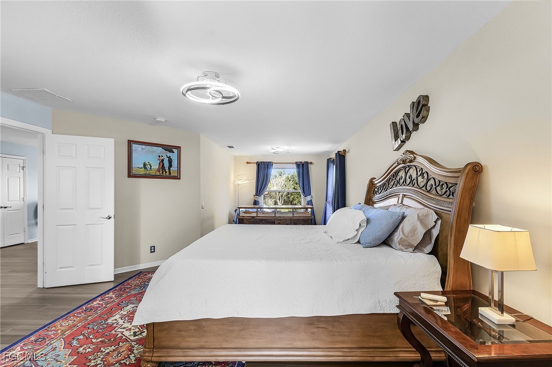 9021 Falcon Pointe Loop Fort Myers, FL 33912 - Photo 28 of 39 a bedroom with a bed and a lamp on dresser
