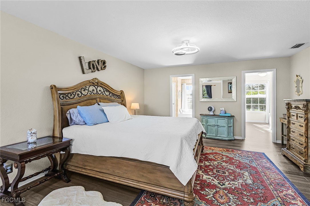 9021 Falcon Pointe Loop Fort Myers, FL 33912 - Photo 33 of 39 a bedroom with a bed rug and wooden floor