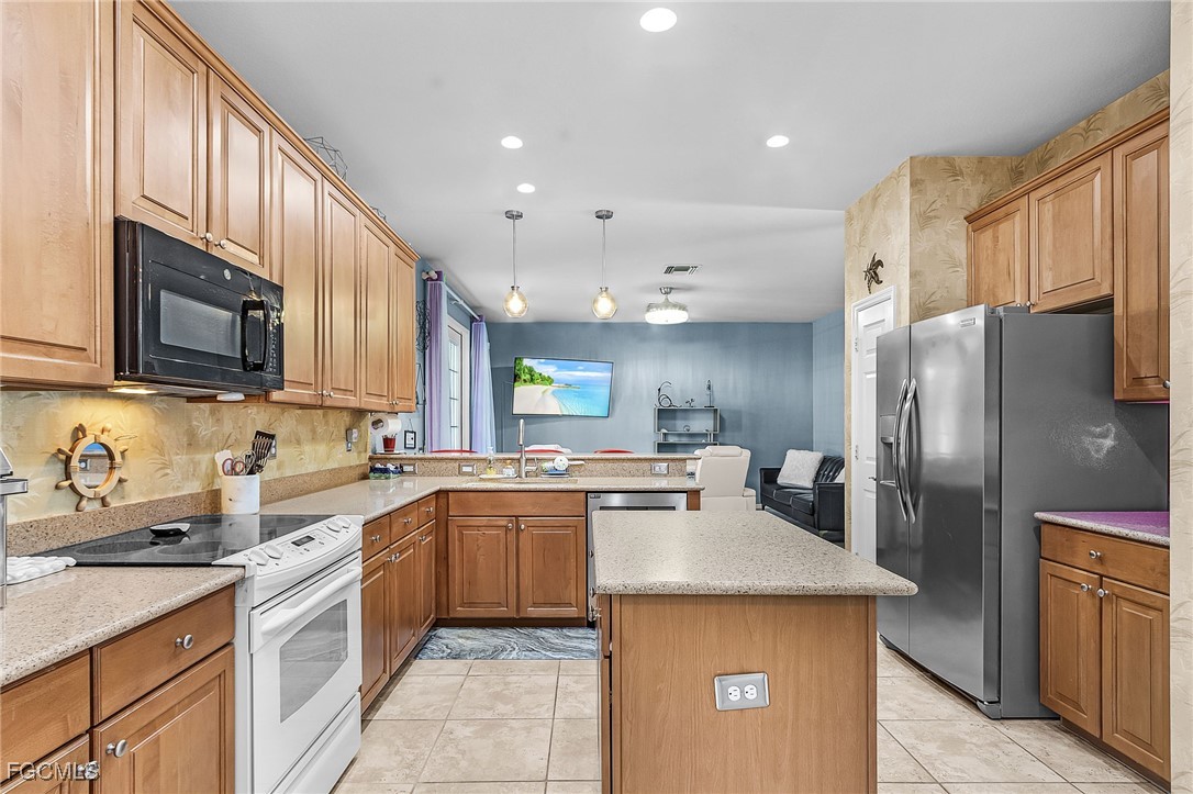 9021 Falcon Pointe Loop Fort Myers, FL 33912 - Photo 10 of 39 a kitchen with stainless steel appliances granite countertop a sink stove refrigerator and cabinets